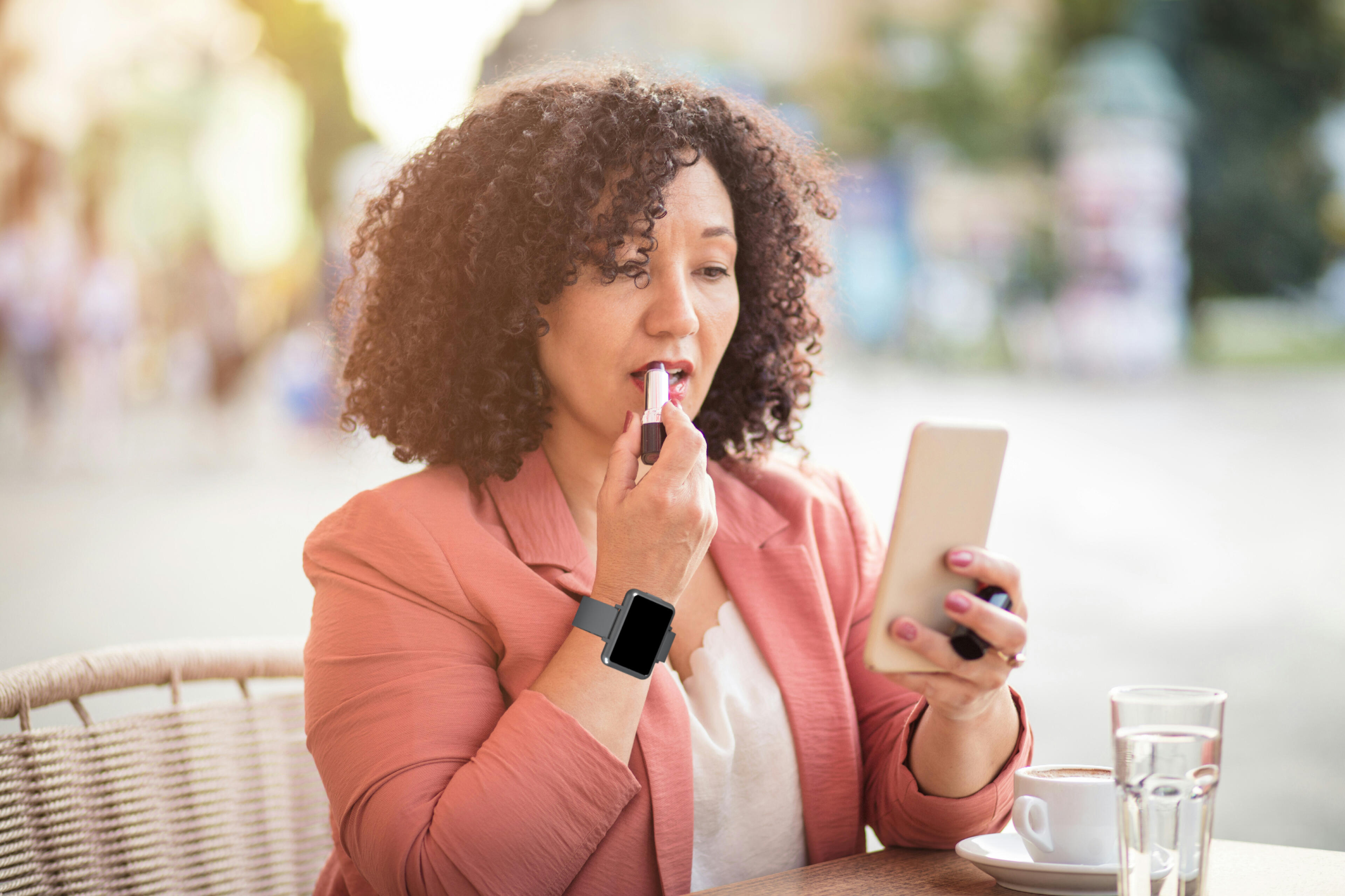 Woman applying lipstick while wearing the Cadence band.